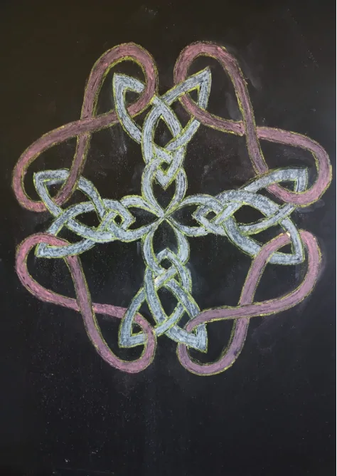 Dibujo de formas en tiza sobre pizarrón: entrelazado en blanco y rosa de simetría cuádruple